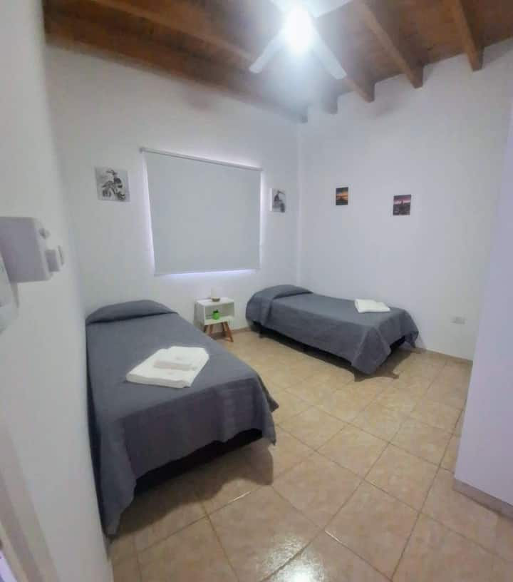 חדר עם 2 מיטות יחיד ושלט. מאוורר תקרה ווילונות האפלה.