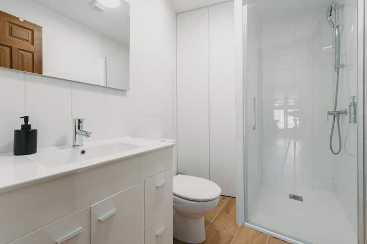 Baño completo 2 con ducha y mueble de lavabo: secador de pelo y toallas.