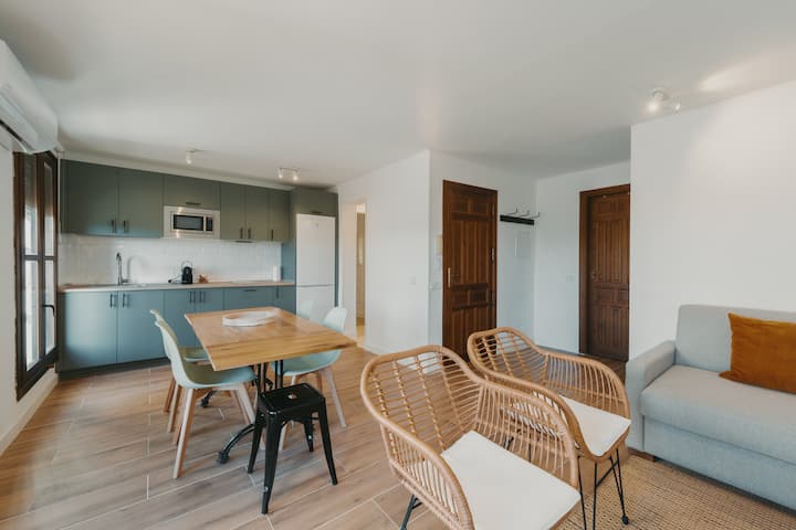 Comedor junto a la cocina: mesa para 6, copas de vino y vajilla completa.