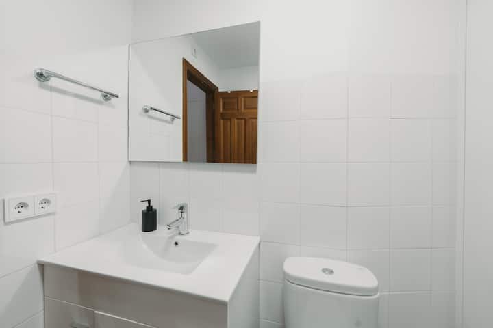 Baño completo 2 con espejo y lavabo amplio para dos personas.