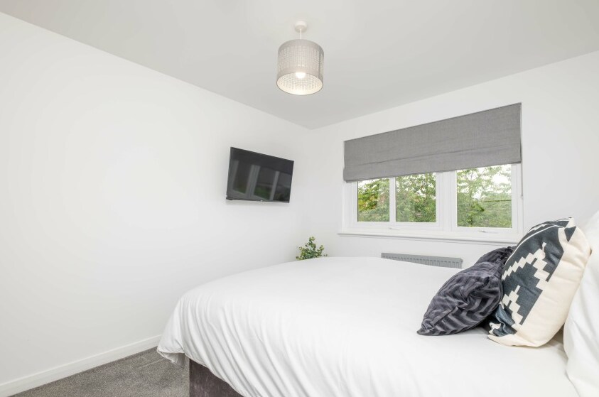 Едноставна, но елегантна спална соба, со удобен двоен кревет и телевизор.