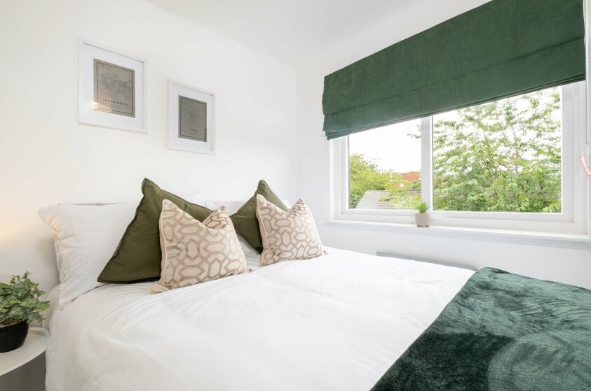 Светла и елегантна спална соба, со удобен двоен кревет.