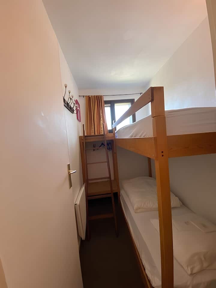 Habitación cabina con dos camas individuales superpuestas. Un espacio de almacenamiento también está presente. Una vista mágica del Mont Blanc desde la cama de arriba:)