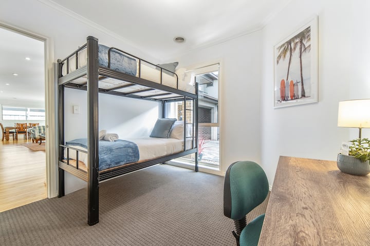 בחדר שינה 3 יש 2 מיטות קומתיים בודדות ושולחן עבודה/משרד שני וכיסא משרדי.