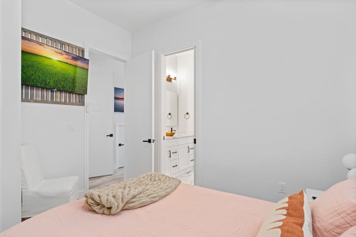 Chambre queen size en bas avec salle de bain jack n jill et grande télévision connectée