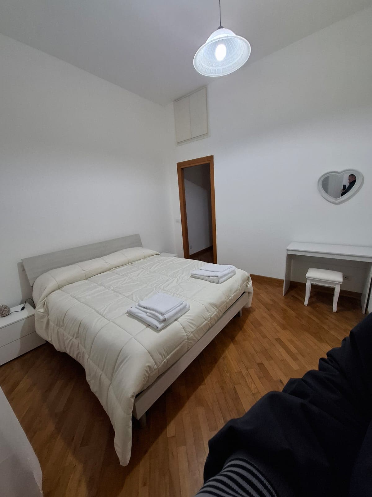 espaciosa habitación con una cama doble, ventana, escritorio y gran vestidor con espejo