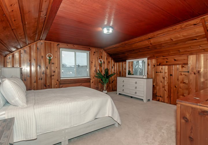 Dormitorio en el segundo piso con cama tamaño Queen y espacio de trabajo 