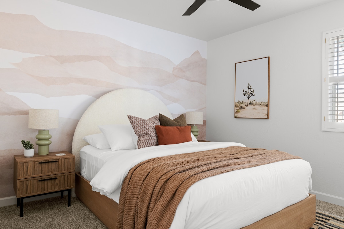 Este acogedor dormitorio con una cama tamaño queen y un sereno mural de montaña que agrega un toque de encanto inspirado en la naturaleza.  