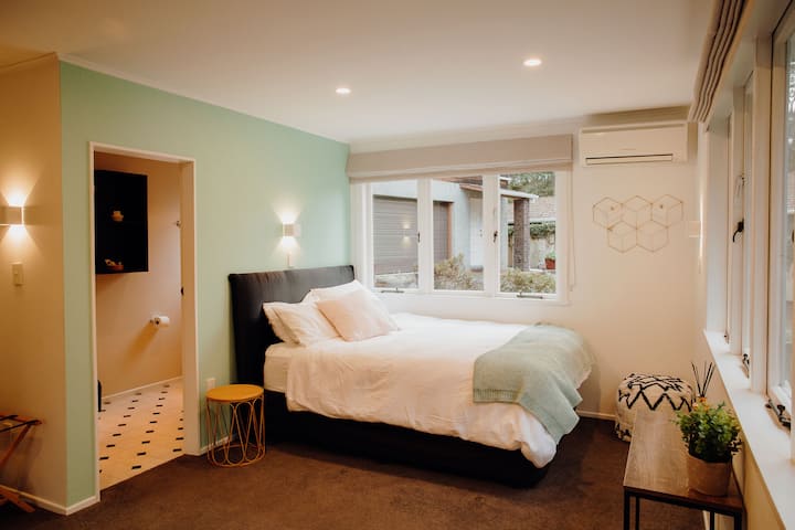 На долния етаж спалня четири предлага уединение и комфорт с двойно легло, самостоятелен санитарен възел, бюро, двоен гардероб и термопомпа. Това тихо и просторно място за отдих е идеално за отдих или работа, с възможност за добавяне на уютен надуваем матрак с двойно легло queen.
