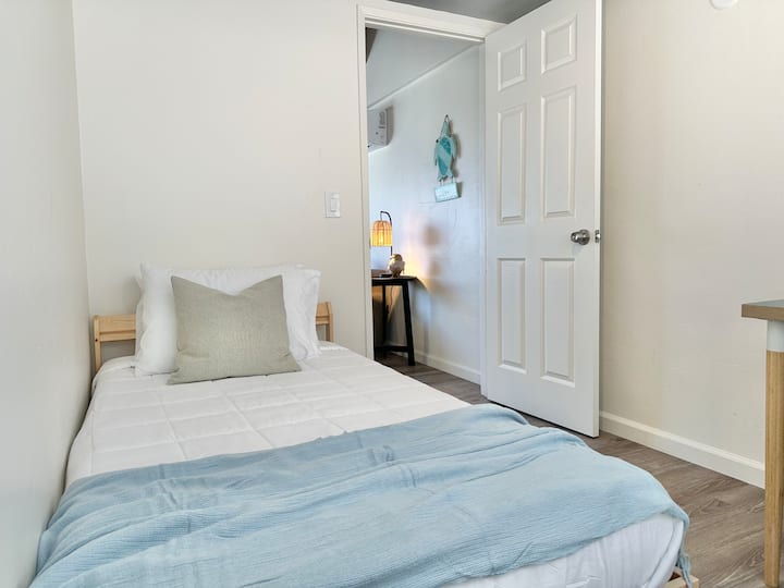 غرفة نوم لشخص واحد مفصولة بغرفة معيشة.