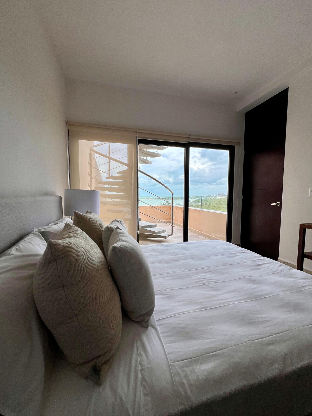 غرفة مجهزة بسرير بحجم كبير وحمام خاص ومخرج بشرفة تطل على البحر.