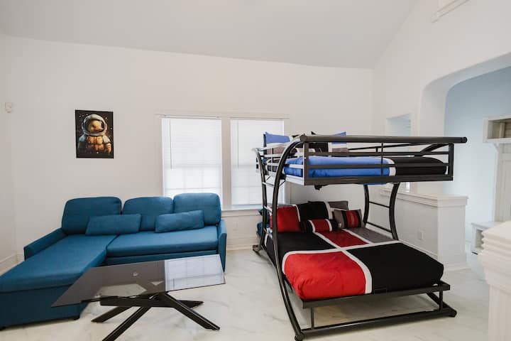 Slaapkamer op de 1e verdieping met volledig boven een stapelbed, een slaapbank en een badkamer in de wasruimte