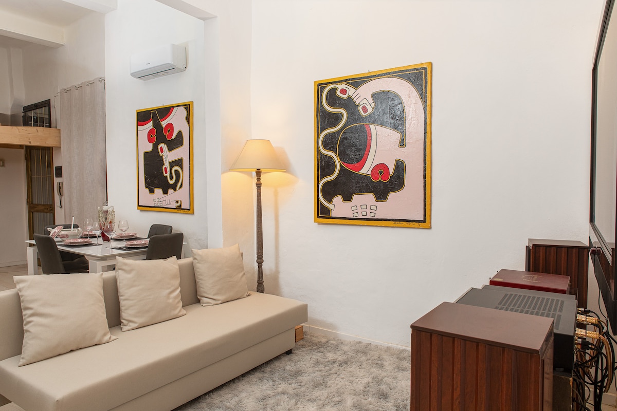 Მისაღები ოთახი სავსეა ორადგილიანი გასაშლელი დივნით, 45-დუიმიანი ბრტყელი ტელევიზორის ეკრანით, სატრიალებელი მაგიდებით, სმარტ-ტელევიზორით