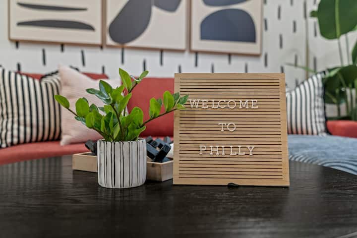 การต้อนรับอย่างอบอุ่นด้วยการตกแต่งที่มีสไตล์ด้วยป้าย 'Welcome to Philly' ต้นไม้ที่มีชีวิตชีวาและบรรยากาศห้องนั่งเล่นที่ทันสมัยอบอุ่น