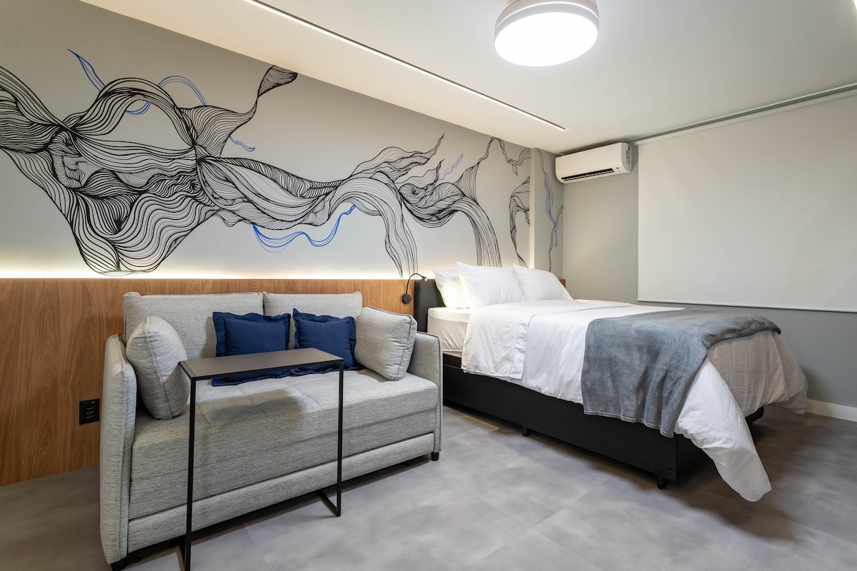 Obývacia izba s rozkladacou pohovkou, šatníkom, Wi-Fi, klimatizáciou, zasúvacím stolom a televízorom.