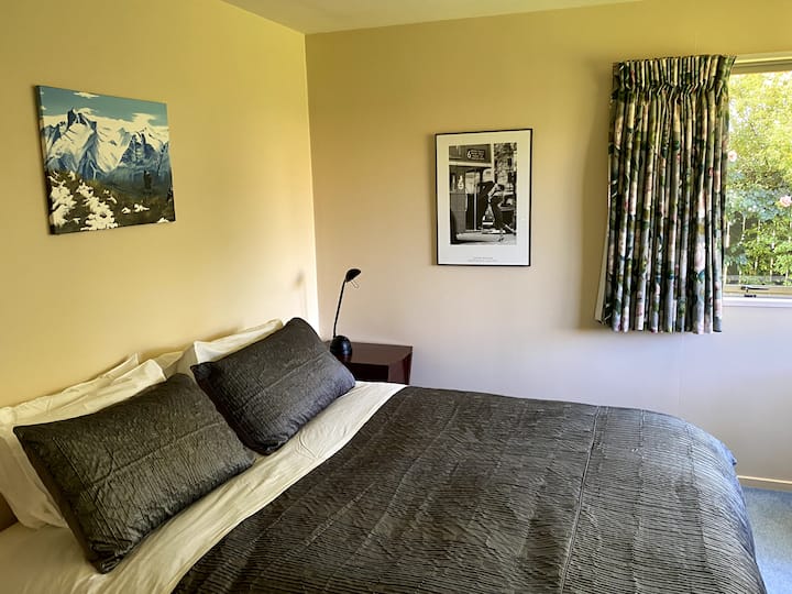 Chumba kizuri cha kulala cha malkia chenye matembezi kwenye kabati la nguo na chumba cha kujitegemea. Dirisha kubwa la ghuba linaloangalia bustani.