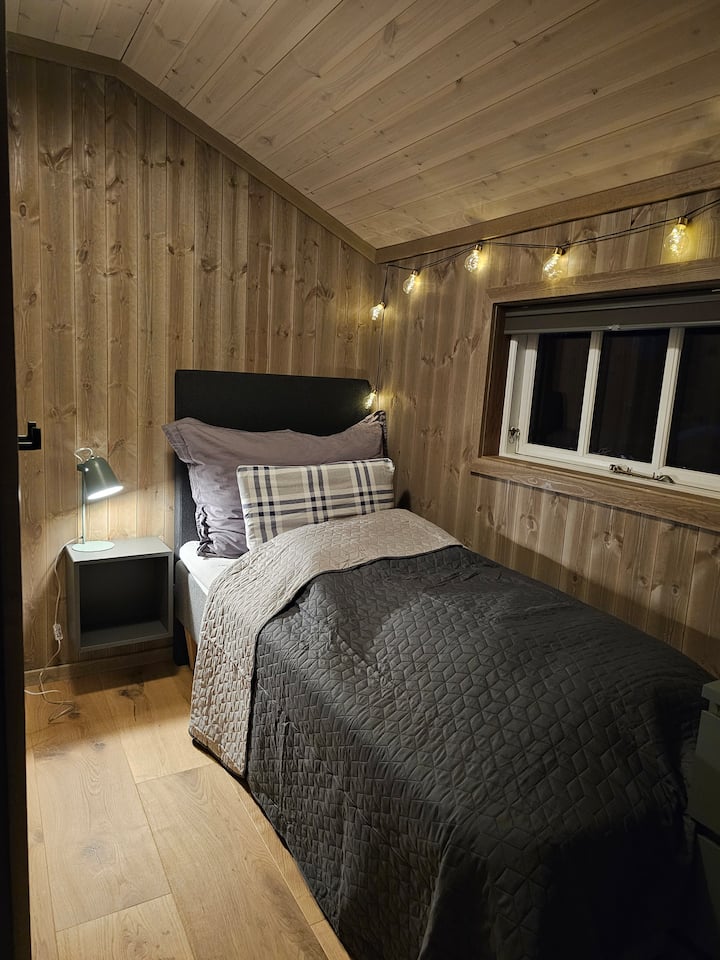 Спалня с единично легло, 90 см. Ярки плътни плисирани завеси. 