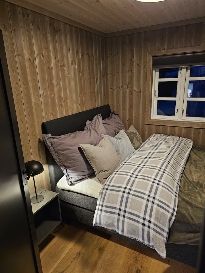 Спалня с двойно легло 150 см. Ярки плътни плисирани завеси. 