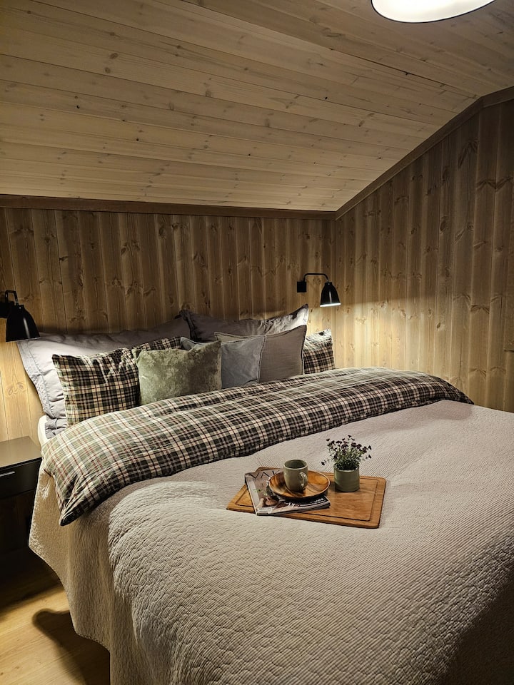 Спалня с двойно легло 180 см. Ярки плътни плисирани завеси.  