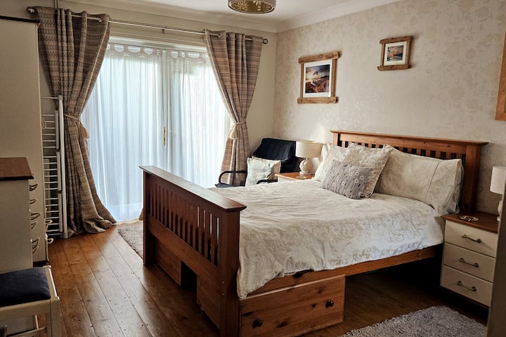 Hoofdslaapkamer met ensuite. Opens van openslaande deuren naar patio en tuin. 