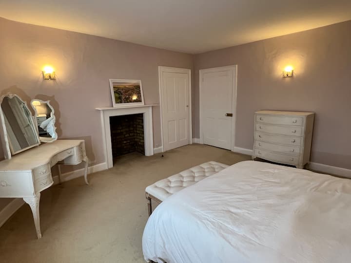 Dormi sonni tranquilli nella lussuosa camera da letto principale con bagno privato, con biancheria da letto soffice e un tocco di eleganza senza tempo, con fantastiche viste a sud sui giardini della Lamb House
