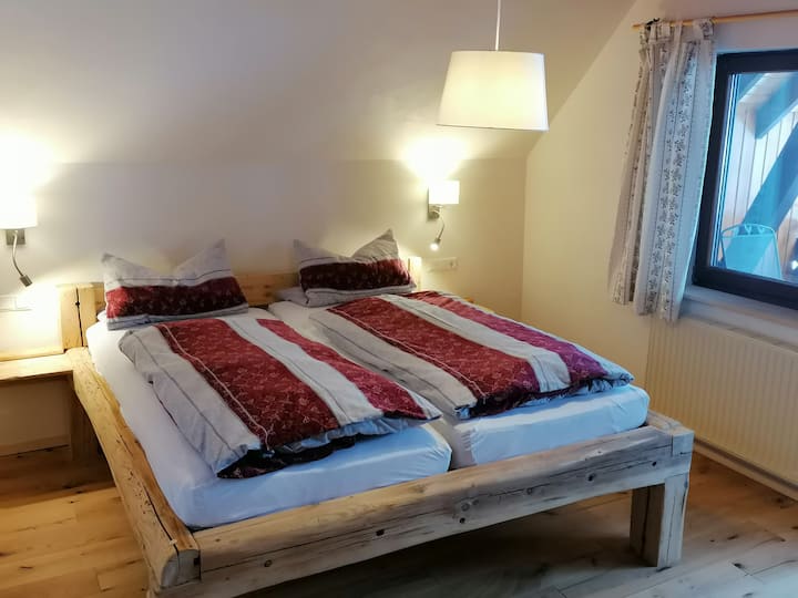 Novouređena spavaća soba s gredama od starog drva iz Mooshofa