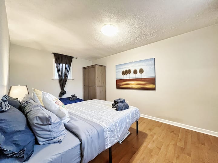 A different view of the cozy bedroom featuring a queen bed and a single bed, perfect for families or small groups.