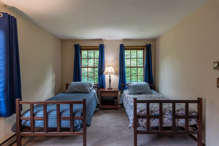 Chumba cha kulala cha ghorofa kilicho na vitanda viwili na sehemu nyingi za kabati na kabati la kujipambia.