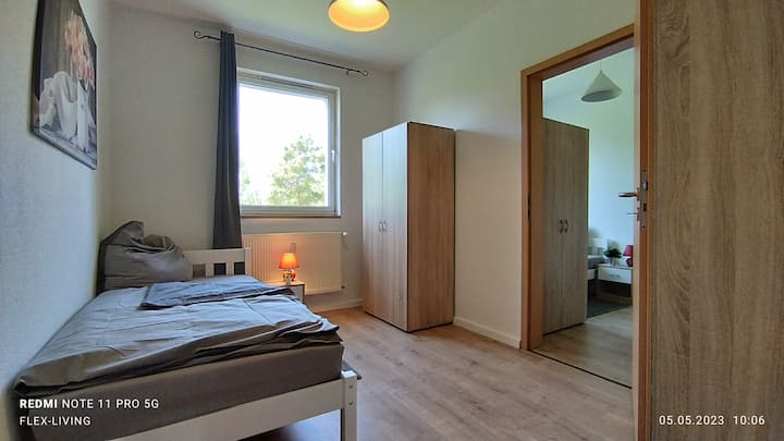 غرفة فردية مريحة بسرير فردي وخزانة ملابس