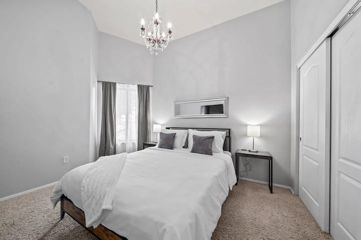 Este dormitorio incluye una cama tamaño queen con almohadas, sábanas y mantas cómodas. Dos mesitas de noche con lámparas que tienen un puerto USB. La cabecera también tiene luces LED incorporadas.