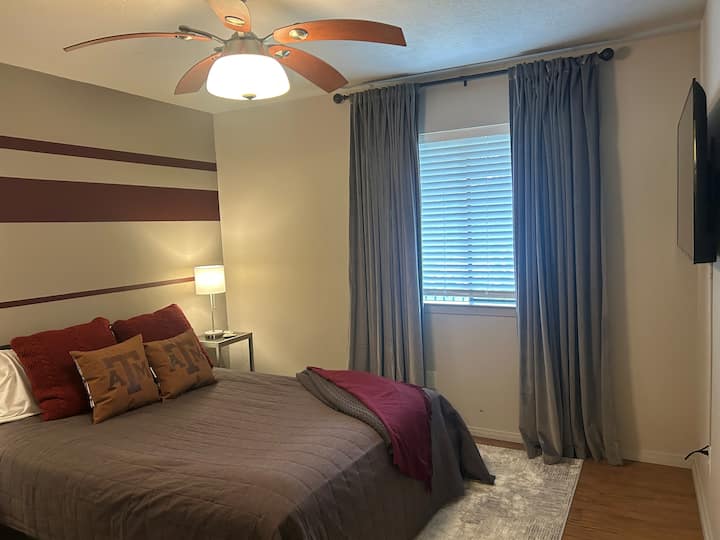 เตียงควีนไซส์พร้อมหมอนและที่นอนนุ่มสบาย  และทีวีขนาด 55 นิ้วสำหรับดูจากบนเตียง