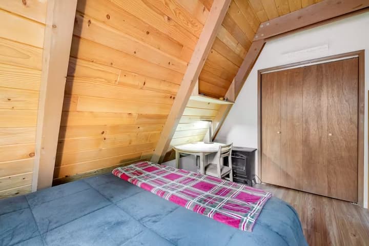 تحتوي غرفة النوم في الطابق السفلي على سرير بحجم كوين