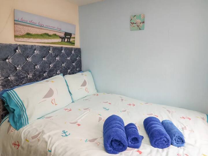 Petit lit double dans la chambre principale. Veuillez noter qu'il est de quelques centimètres plus petit dans la largeur qu'un double standard pour tenir dans la pièce sans bloquer la porte.