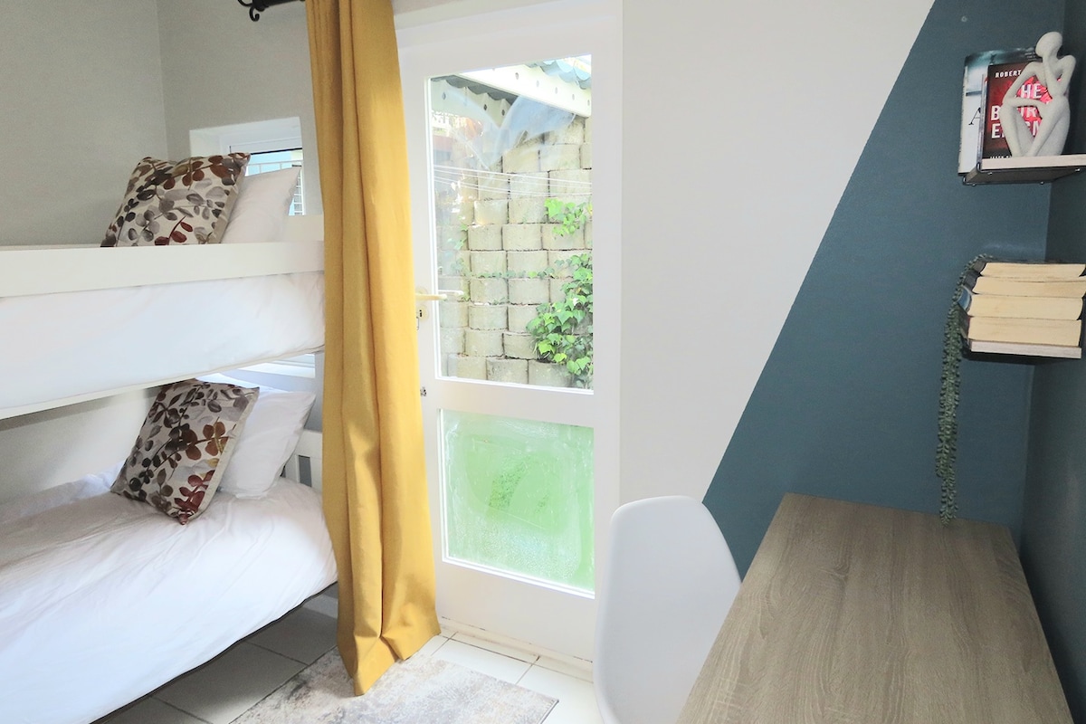 Lichte en vrolijke kamer met een stevig stapelbed, ideaal voor kinderen of vrienden. Met een bureau, boekenplanken en directe toegang naar buiten – perfect om te studeren, te spelen of rustig uit te rusten.
