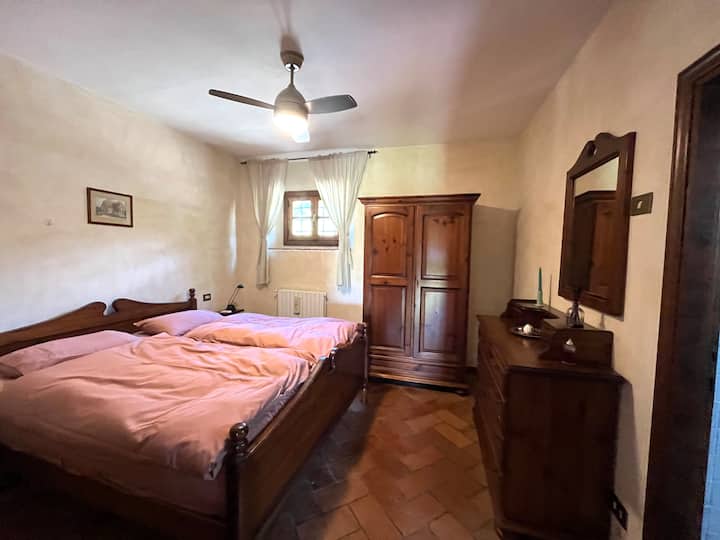 Dormitorio rústico de estilo toscano con ventilador de techo.