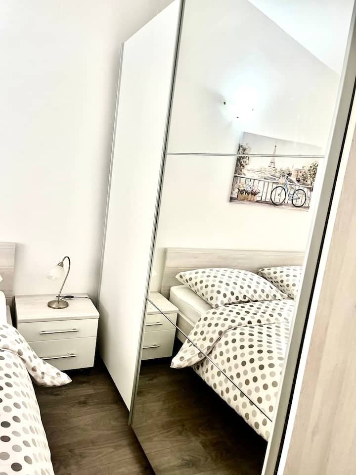 Chumba hiki cha kulala chenye starehe kina kitanda cha ukubwa wa kifalme na kitanda, na kukifanya kuwa chaguo bora kwa familia zilizo na watoto wadogo. Kabati la mlango linaloteleza lenye kioo hutoa hifadhi ya kutosha kwa ajili ya vitu binafsi.