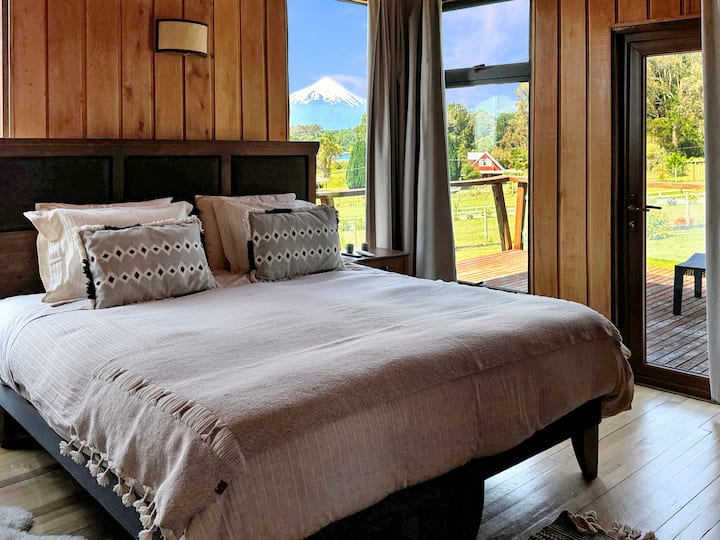 Основната стая разполага с вкусно двойно легло king size, със светло и сияйно пробуждане с директен изглед към вулкана и собствен балкон.