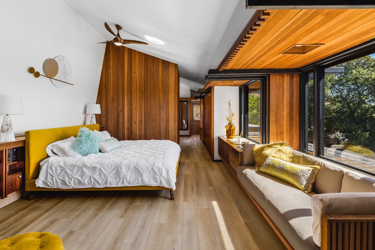 تتميز غرفة النوم الهادئة والأنيقة هذه بلمسات خشبية دافئة ومقعد نافذة مريح ونوافذ كبيرة تطل على مناظر الغابة الهادئة للاسترخاء التام.