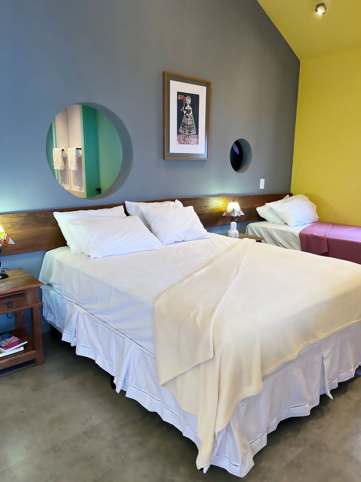 Quarto que fica atrás da suíte master. Essa suíte da foto tem uma cama queen e uma de solteiro. Ao fundo, o banheiro