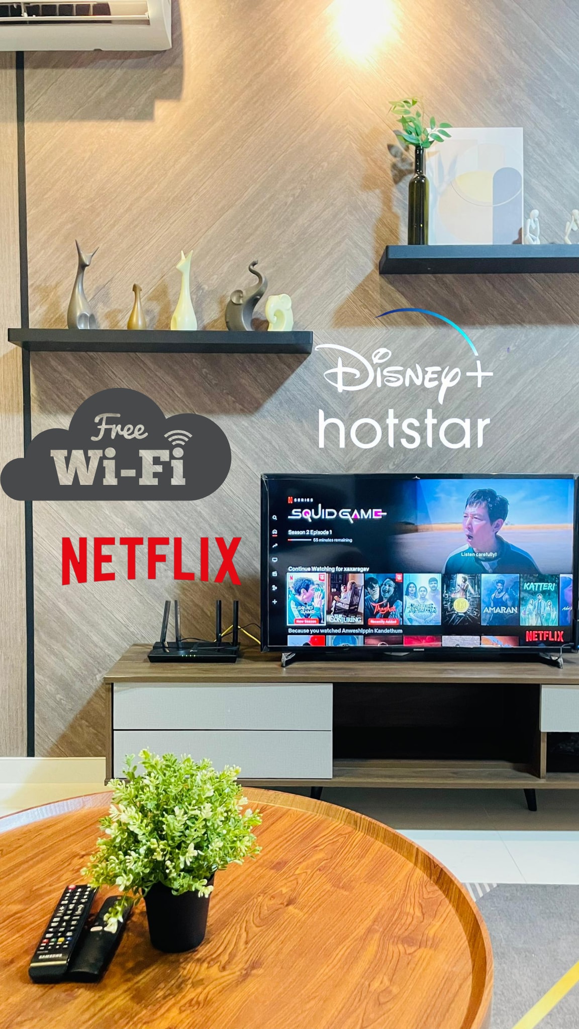 A cozy living area is presented, featuring a modern entertainment unit with a 42-inch smart TV displaying streaming options for Netflix and Disney+. A round wooden coffee table with a small green plant adds a touch of nature, complementing the overall design.