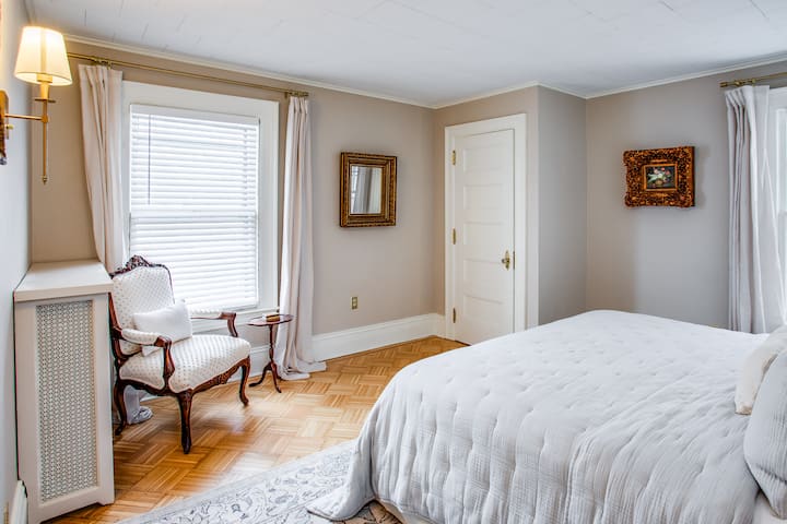 Spavaća soba s bračnim krevetom i prostorom za sjedenje. 

