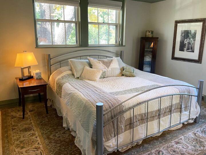 חדר שינה שני למעלה עם מיטת קינג סייז וסלון צמוד עם טלוויזיה.