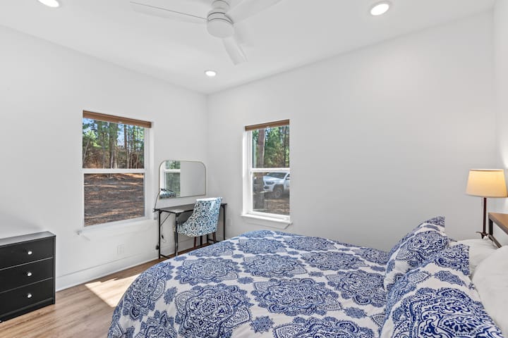 Dormitorio 1 - Incluye una cama tamaño queen con escritorio de trabajo y espejo de tocador, así como una puerta extra ancha para facilitar el acceso en silla de ruedas.