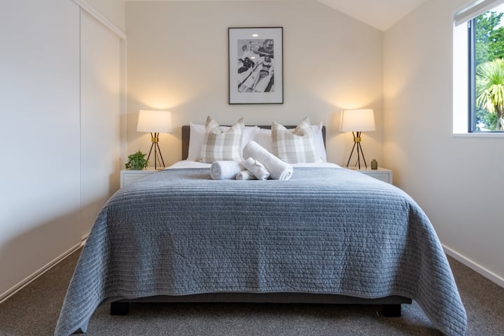 Lujosa cama tamaño queen con ropa de cama cómoda y sábanas de hotel de 5 estrellas.