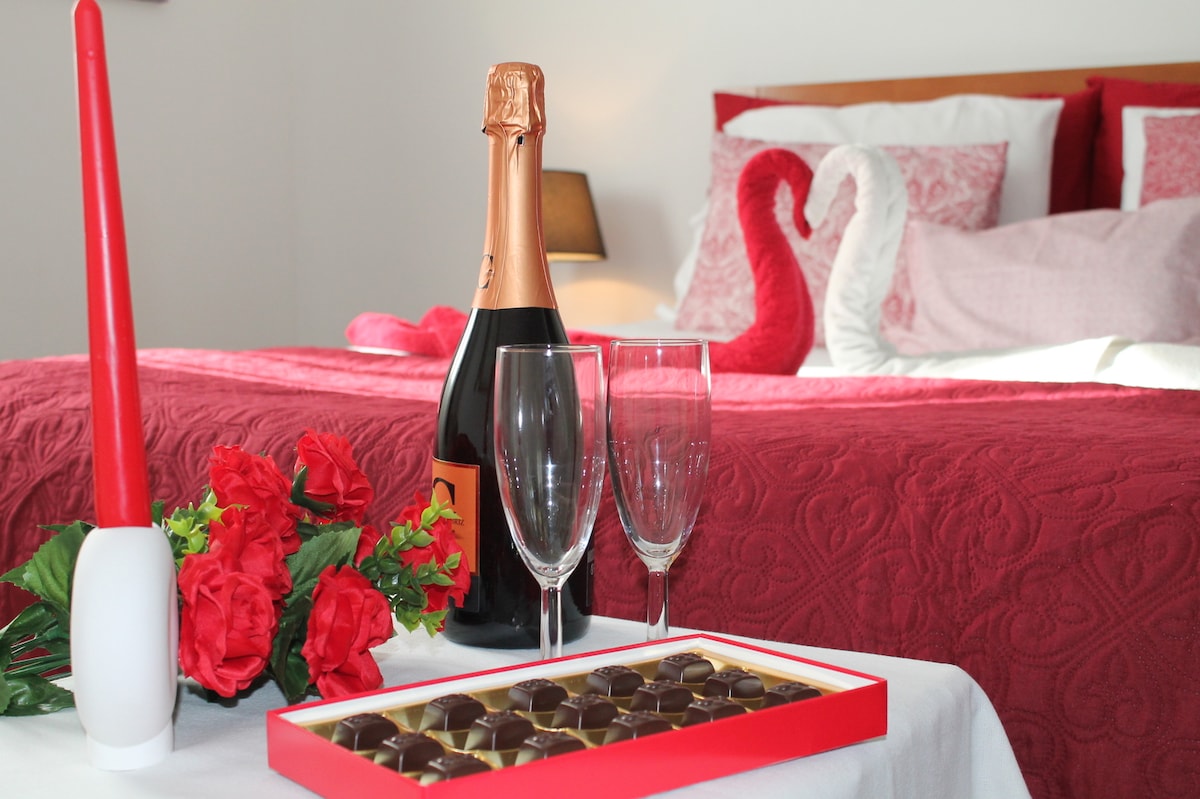 Quarto confortável e sereno, com cama de casal, roupa de cama cuidada e ambiente romântico. 