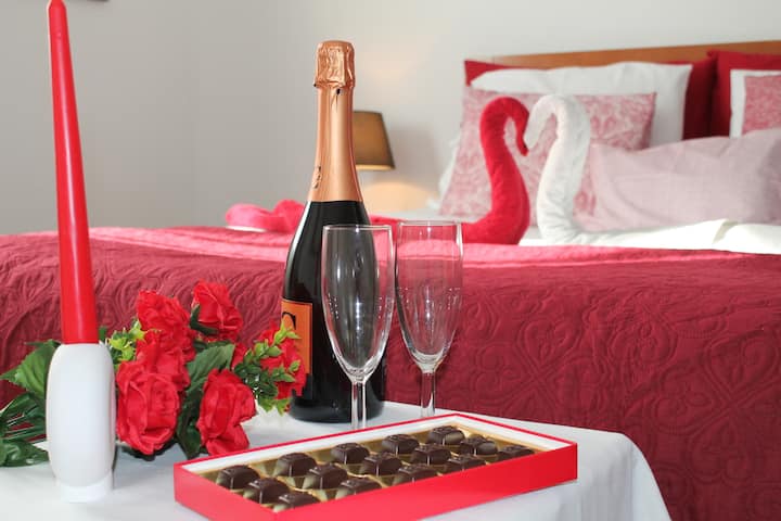 Quarto confortável e sereno, com cama de casal, roupa de cama cuidada e ambiente romântico. 