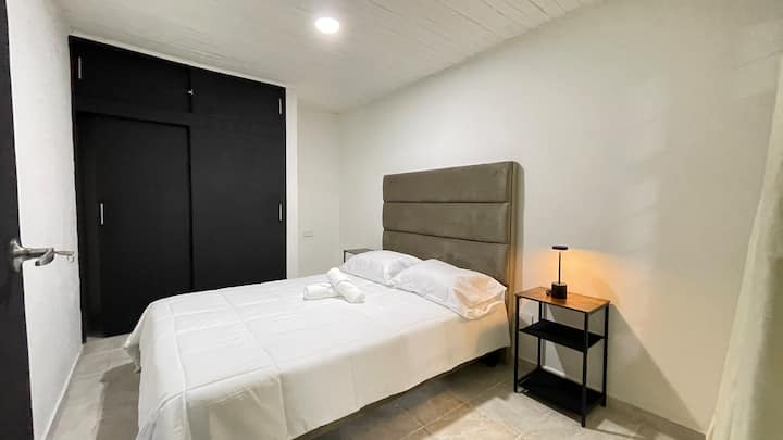 Habitación con una cama doble y limpia que hacen placentera tu estadia.