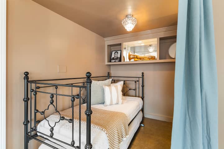 Dormitorio2 con dos camas individuales, un mostrador de maquillaje y cortinas que oscurecen la habitación como divisor de habitaciones para mayor privacidad. 