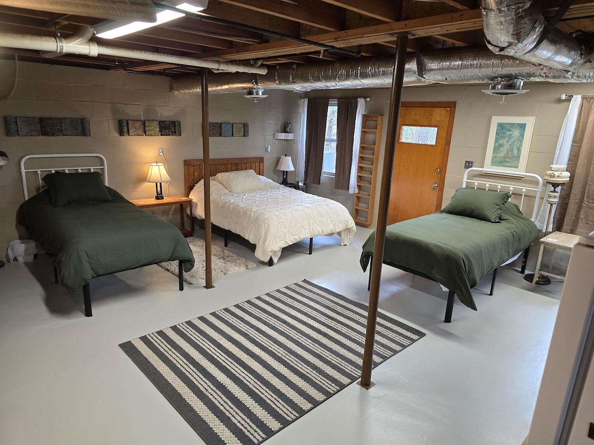 Lower level basement sleeping area including 1 x Queen and 2 x Twin-XL firm beds on reinforced steel bed frames.
