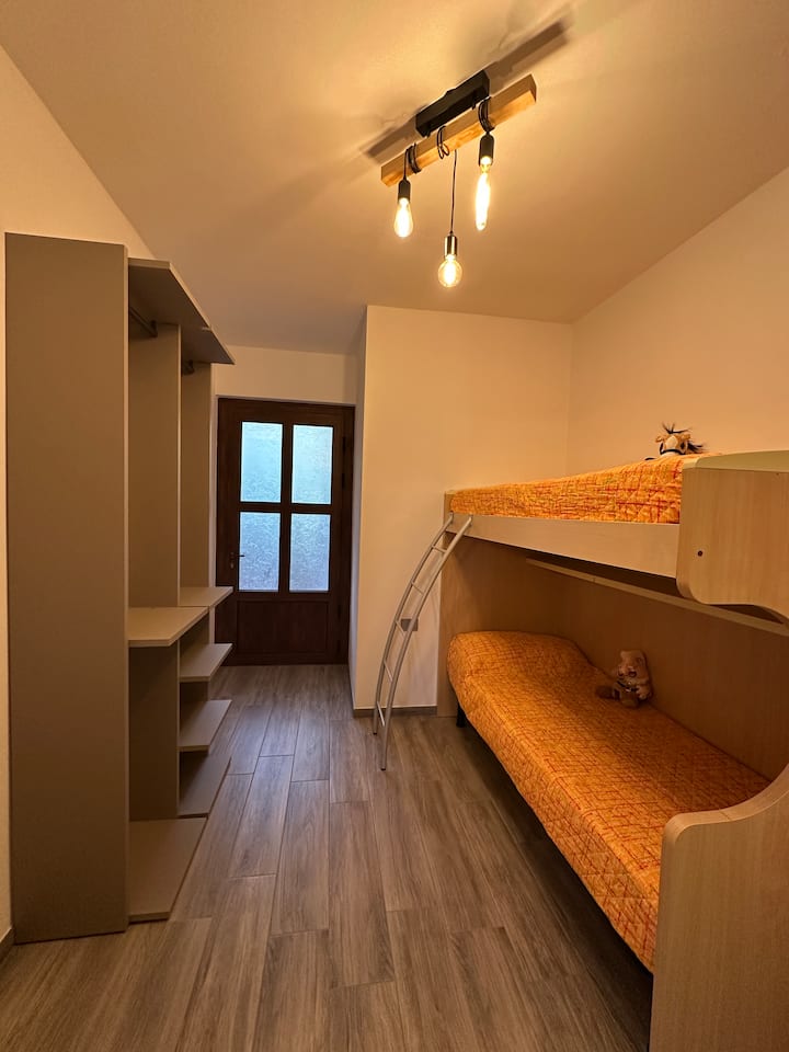 Dhomë gjumi me krevat marinari ideal për fëmijët me dalje në verandën ekskluzive dhe e pajisur me një dollap të ekspozuar.